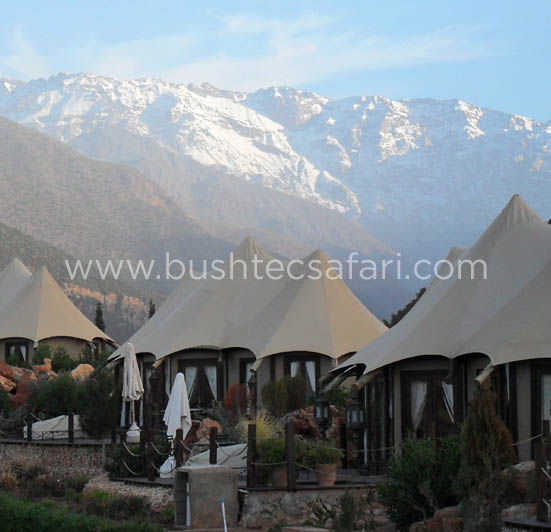 Glamping tents on rock deck overlooking snowcapped mountains