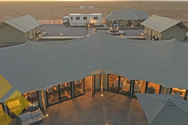 Aerial of camping tents and wooden deck in desert