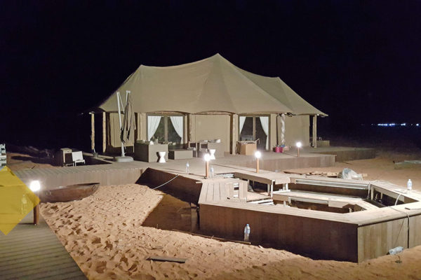 Exterior of tent and firepit in the evening in the desert