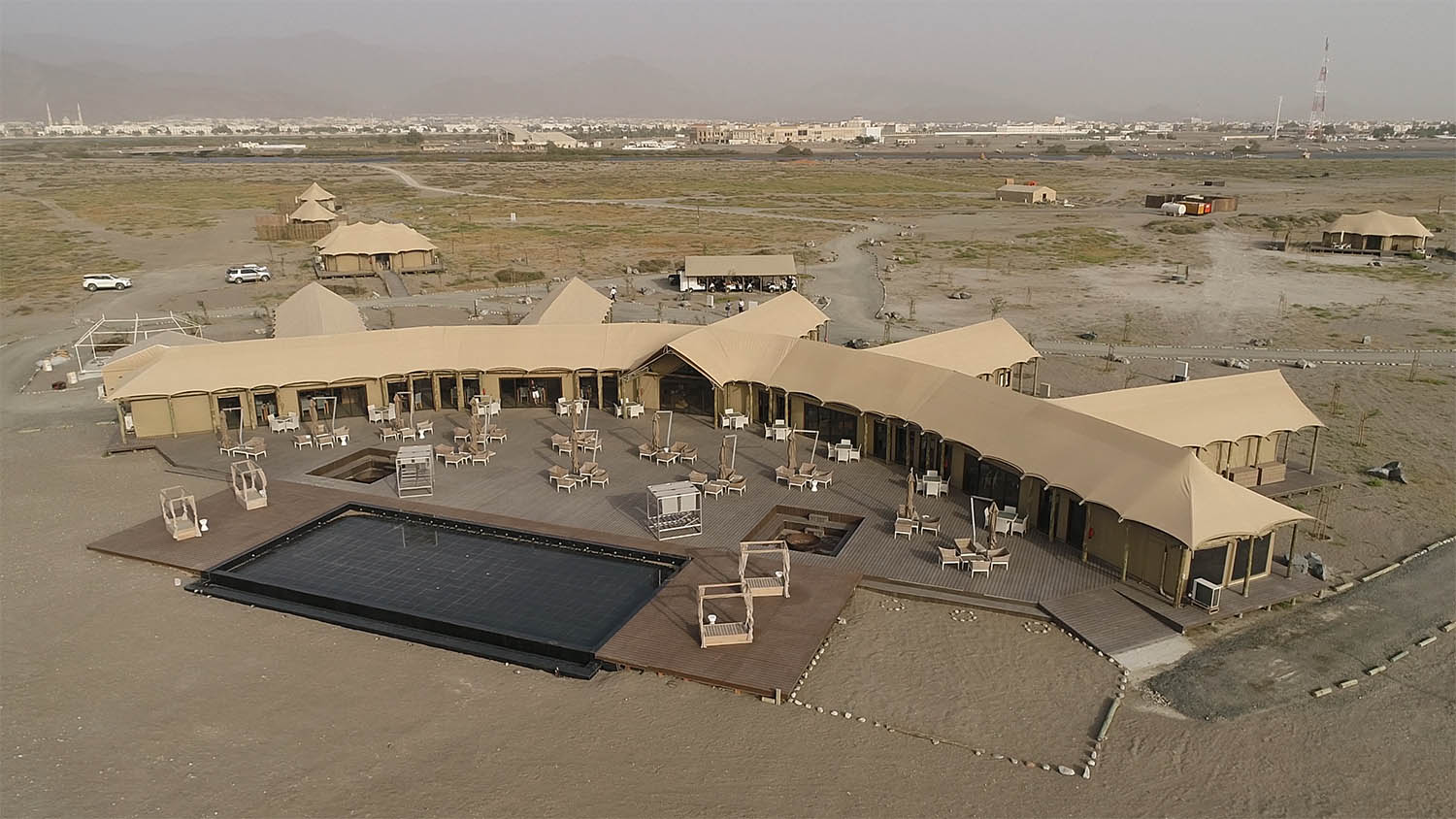 Aerial of a glamping resort in the desert with a pool